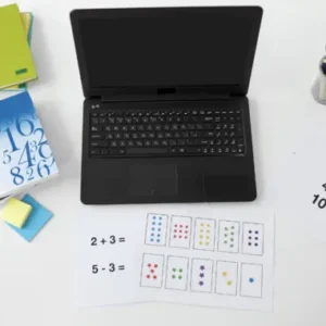 Books, sticky notes, laptop, cup with pens, and papers with math equations on a table.
